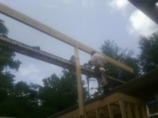 Carpenter setting a ridge beam over a new addition frame — Ice Dam Removal by Roofing Brothers in New Milford