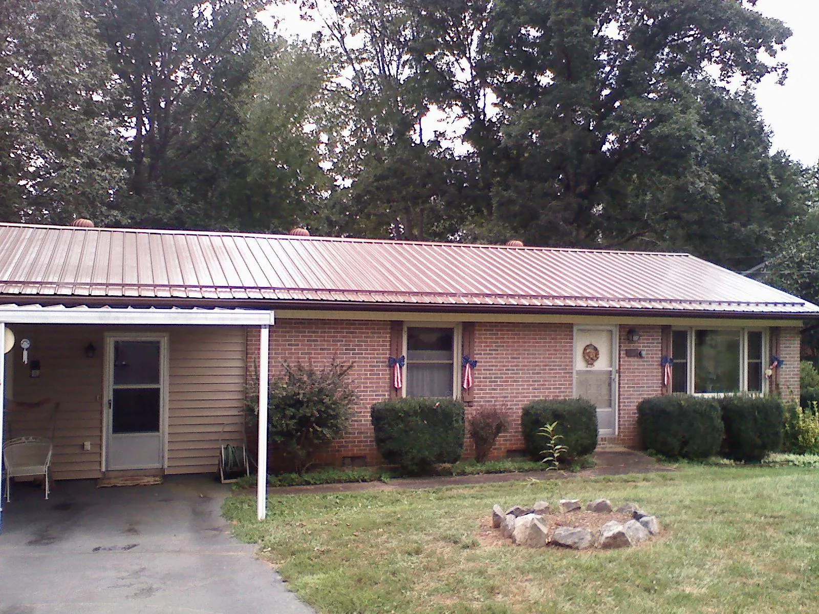 Bronze metal roof and carport on a brick ranch home — Roof Repair work by our crew in New Milford